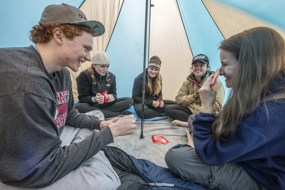 Photo of students in a tent playing cards