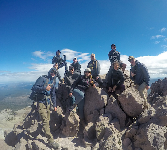 Photo of a group of students in a rock cropping on a mountian