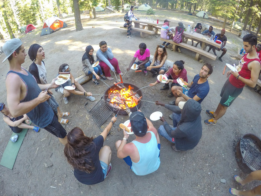 Photo of students making s'mores around a campfire