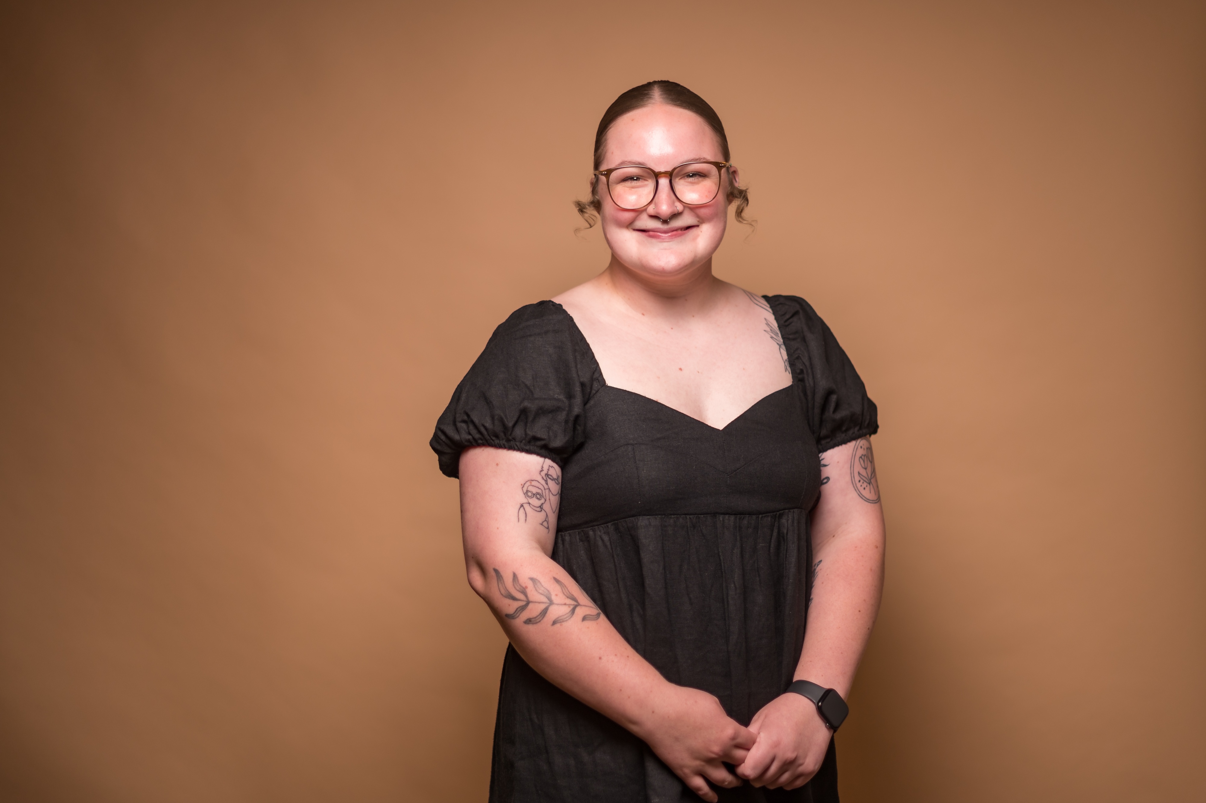 Photo of a student posing in front of a tan background.