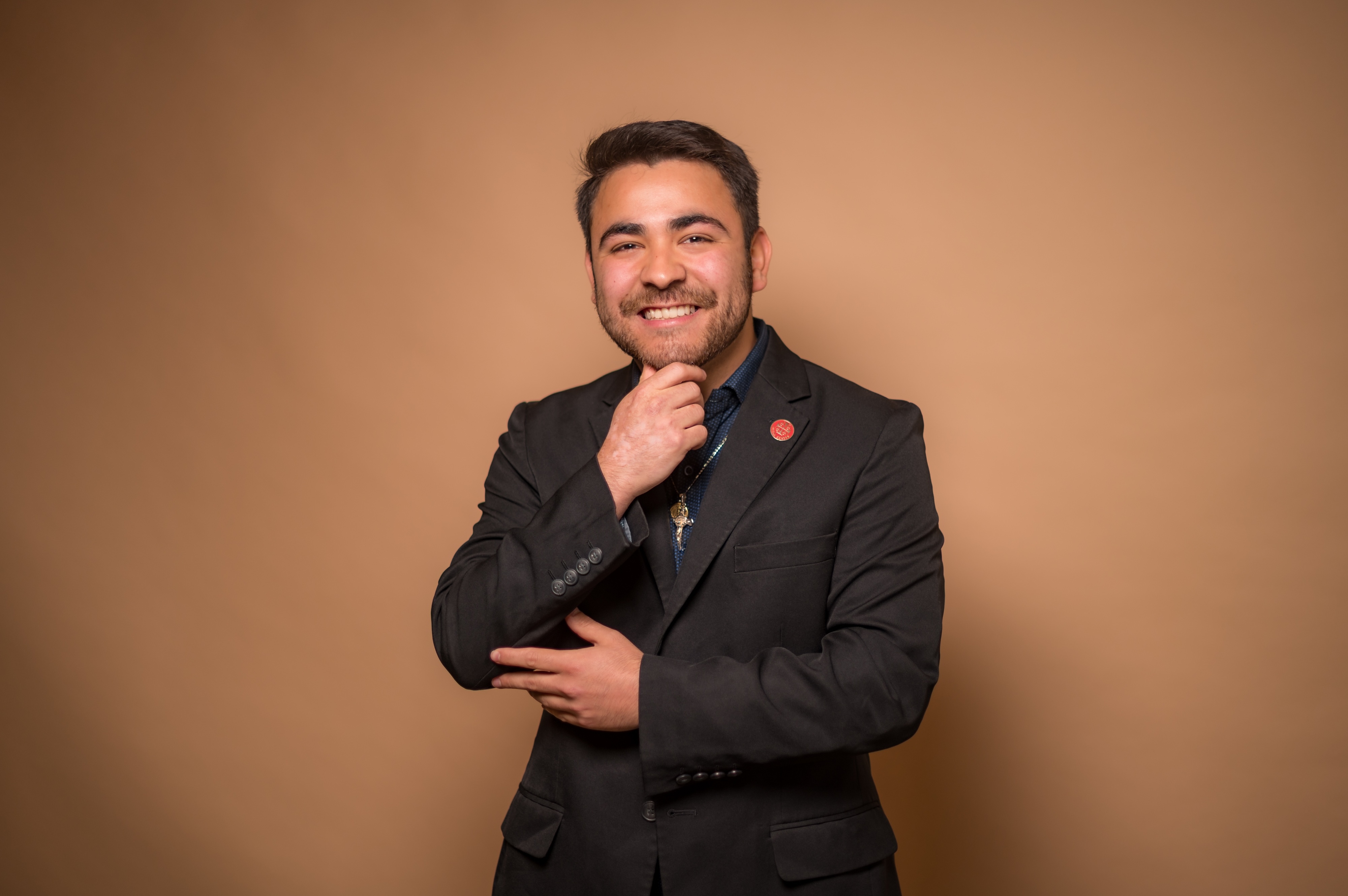 Photo of a student posing in front of a tan background.