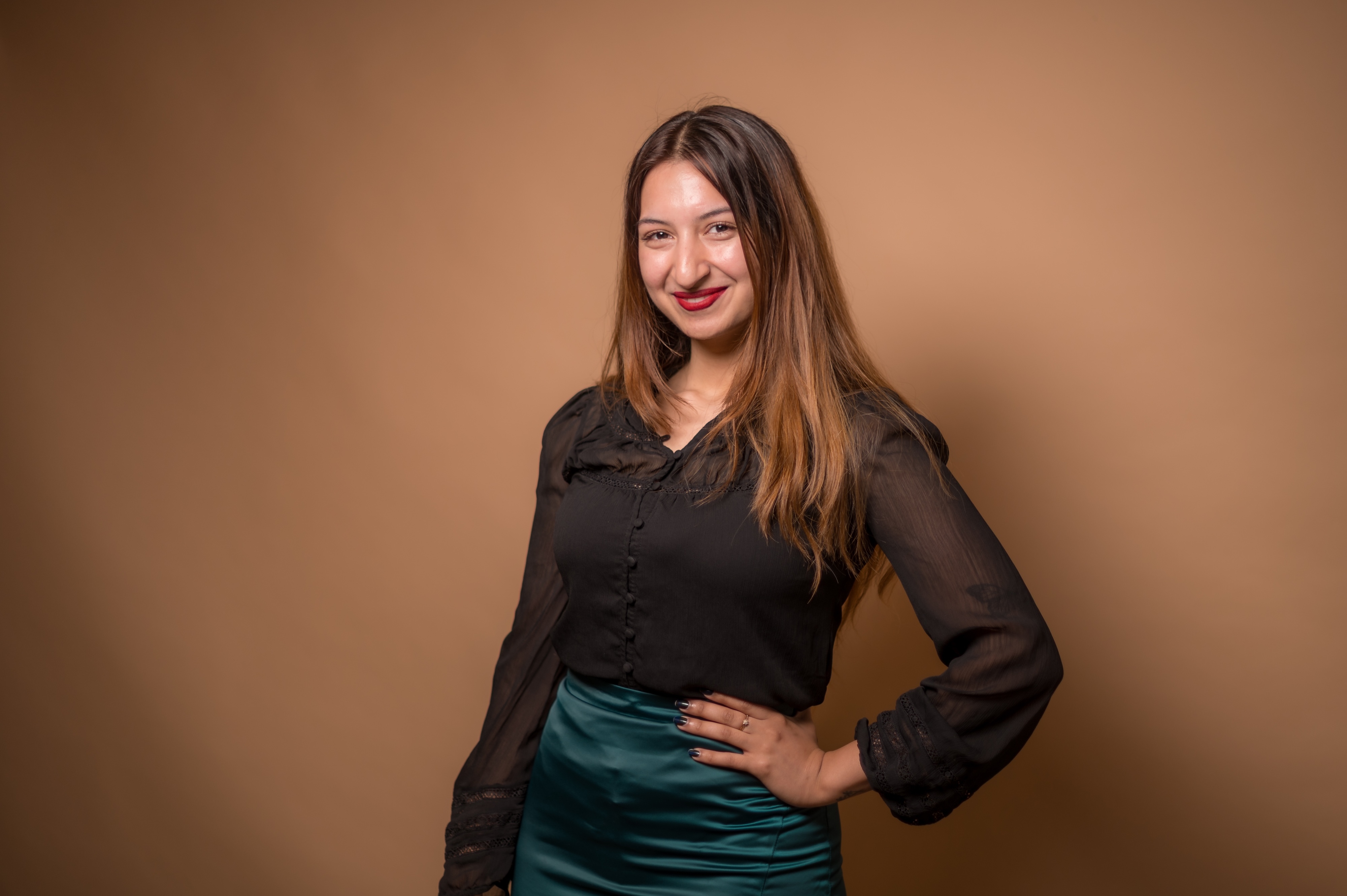 Photo of a student posing in front of a tan background.