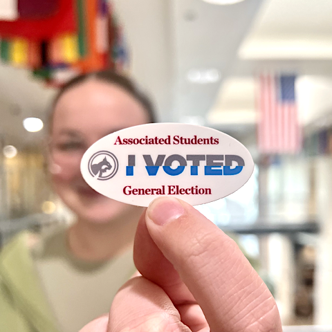 Photo of student holding 'I Voted' sticker