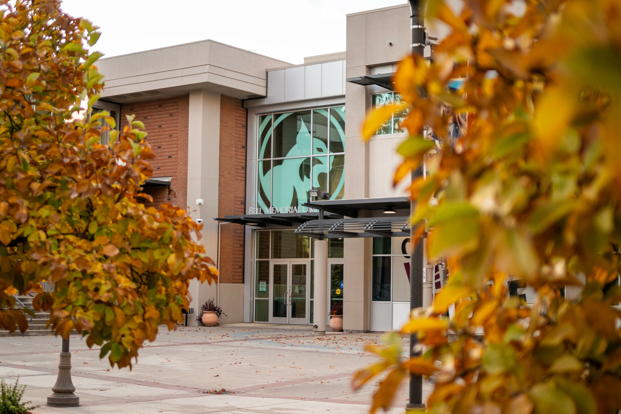 Image of the front of the Bell Memorial Union from the outside with autumn trees framing the left and right side of the image.