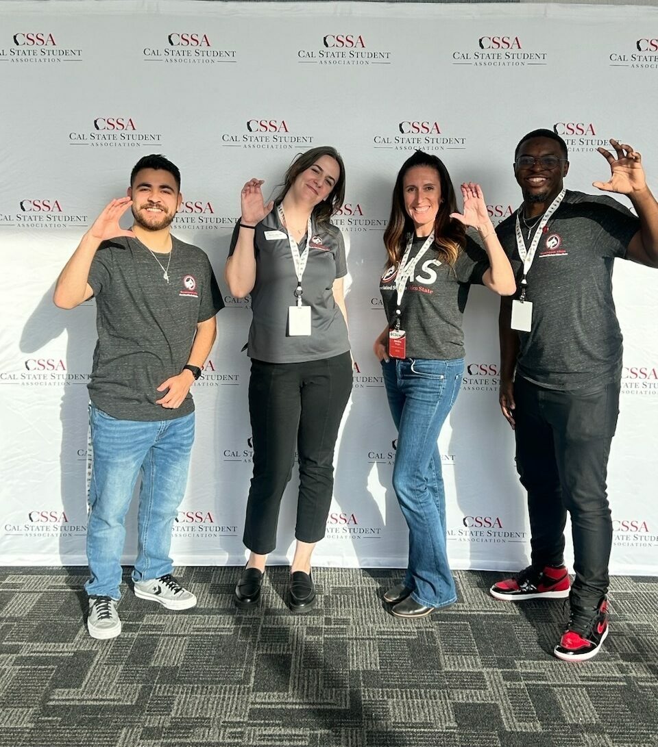 a group holding up a C with their hands